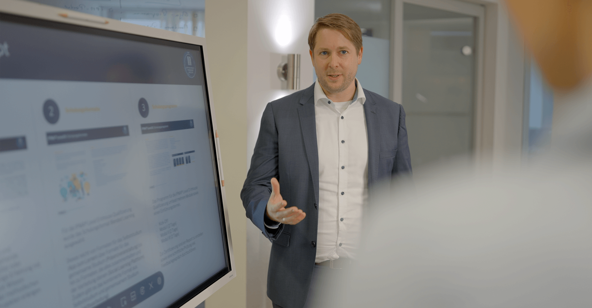 Markus Hegeler stellt einem Mitarbeiter die Vorteile des Prozessmanagements mithilfe einer Präsentation vor.